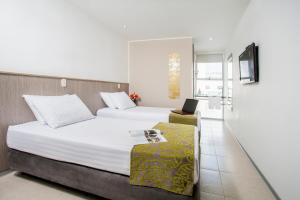 Eco Star Hotel في إباغويه: غرفة نوم بسرير كبير وعليها لاب توب