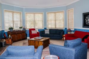 a living room with blue and red furniture and windows at Plumes Boutique Bed & Breakfast in Tamworth