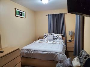 een kleine slaapkamer met een bed en een raam bij El SHADDAI in Orlando