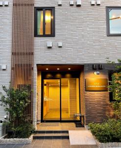 a building with a glass door in front of it at SHINJUKU WARM HOUSE in Tokyo