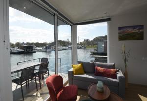 uma sala de estar com um sofá e vista para a água em Floating vacationhome Sylt em Maastricht