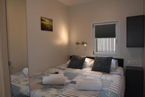 ein kleines Schlafzimmer mit einem Bett und einem Fenster in der Unterkunft Floating vacationhome Sylt in Maastricht