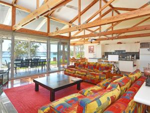 a living room with couches and a table at Lake Macquaries' Edgewater Lakehouse at Morisset Memories in Morisset East