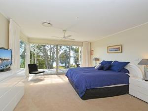 ein Schlafzimmer mit einem großen Bett und einem TV in der Unterkunft Lake Macquaries' Edgewater Lakehouse at Morisset Memories in Morisset East