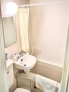 a bathroom with a sink and a toilet and a mirror at COCO Nakameguro301 in Tokyo