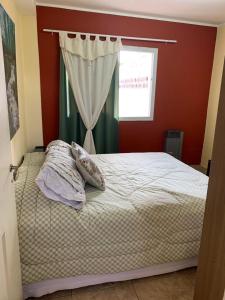 ein Schlafzimmer mit einem Bett mit einem Fenster und einem Vorhang in der Unterkunft Multiespacio Turismo-Trabajo Av Entre Ríos in Salta