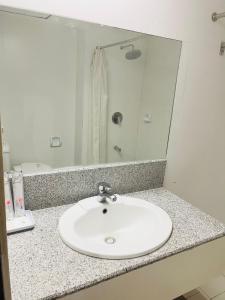 um balcão de casa de banho com um lavatório branco e um espelho em Maharajah Hotel em Angeles