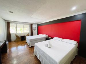 1 dormitorio con 2 camas y pared roja en Maharajah Hotel, en Ángeles