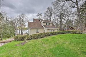 a house on top of a grassy hill at Waterfront Fond du Lac Home on DeNeveu Lake! in Fond du Lac