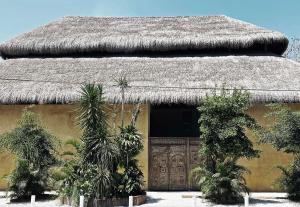 a large white building with a large blue umbrella at Hotel Casa Hormiga in Bacalar