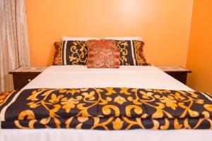 a bed with a black and yellow blanket on it at Perfect vacation villa in Montego Bay