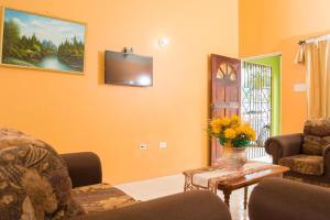 a living room with orange walls and a tv at Perfect vacation villa in Montego Bay