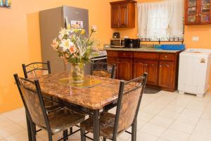 a kitchen with a table with a vase of flowers on it at Perfect vacation villa in Montego Bay