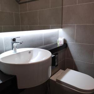 a bathroom with a white sink and a toilet at SRITEL BOUTIQUE HOTEL in Shah Alam