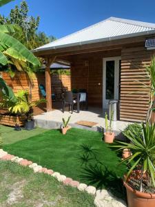 a small yard with a patio with grass and plants at An Ti Kaz La in Sainte-Anne