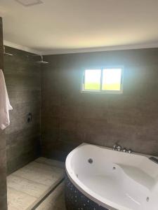 a bath tub in a bathroom with a window at Al Nair Casa de playa RESERVA CON SEÑA in La Pedrera