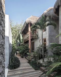 a house with a wooden walkway in front of it at Hotel Casa Hormiga in Bacalar