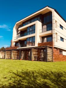 a building with a grass field in front of it at D&N Apartments Синеморец in Sinemorets