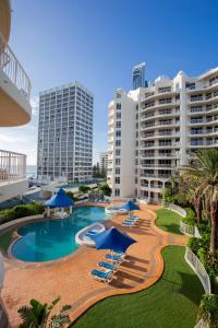 un complejo con piscina con sombrillas y sillas azules en BreakFree Moroccan, en Gold Coast