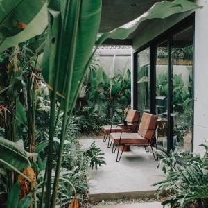 a patio with chairs and a table and plants at T Lofts in Seminyak