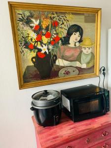een schilderij en een magnetron op een dressoir bij Le Saint Loup (terrasse et parking) in La Ciotat