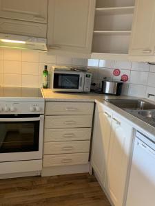 a kitchen with a microwave and a sink at Cosy apartment in the city center in Kemi