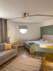 a living room with two beds and a couch at Cosy apartment in the city center FREE PARKING in Kemi