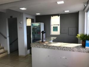 a kitchen with a counter and a refrigerator in a room at Hotel Goiânia in Goiânia