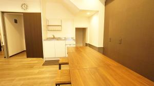 a kitchen with a table, chairs and a refrigerator at House Ikebukuro in Tokyo