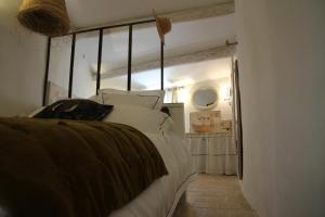 a bedroom with a large bed with white pillows at LE PASSAGE in Lourmarin