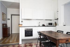 a kitchen with a wooden table and white cabinets at YouHosty - Arnaboldi 15 in Milan