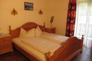 a bedroom with a wooden bed with white pillows at Ferienwohnung Leitenlehen in Berchtesgaden