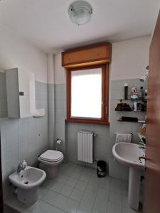a bathroom with a toilet and a sink and a window at Pisco Home in Milan