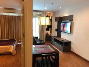Phuket villa best location pool view في شاطيء باتونغ: غرفة معيشة فيها سرير وتلفزيون في غرفة