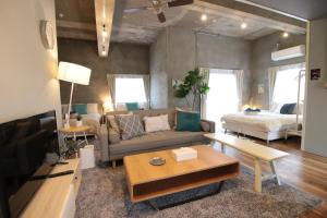 a living room with a couch and a bed at Plus Life Ishigaki in Ishigaki Island