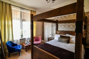 a bedroom with a canopy bed and a blue chair at Hillcrest Whitby in Whitby