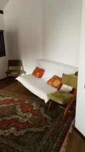 a bedroom with a bed and two chairs and a rug at Pension Casa Contelui in Râşnov
