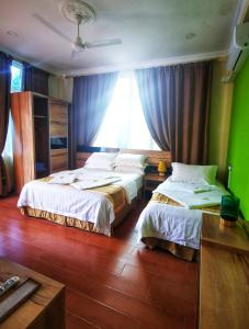 a hotel room with two beds and a window at Mirian Sky in Gaafaru
