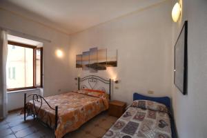 a bedroom with two beds and a window at Bilocali ALTAMAREA - zona mare con clima e terrazze in Marina di Campo