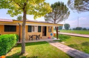 a small yellow house with a table in a yard at Centro Vacanze Verde Azzurro in Cingoli