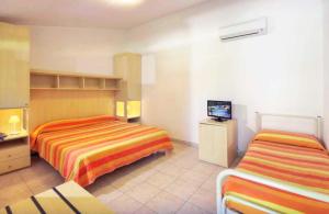 um quarto de hotel com duas camas e uma televisão em Centro Vacanze Verde Azzurro em Cingoli