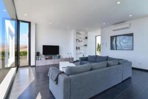 uma sala de estar com um sofá e uma televisão em Villa Iconic em La Asomada