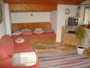 a bedroom with a red bed and a tv at Kilianhof in Berchtesgaden