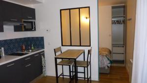 - une cuisine avec une table et des chaises dans la chambre dans l'établissement Appartement tout équipé avec piscine proche Stade OL et EUREXPO, à Meyzieu