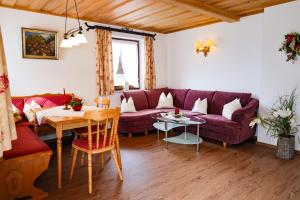 a living room with a purple couch and a table at Haus Kehlsteinblick Hettegger in Berchtesgaden