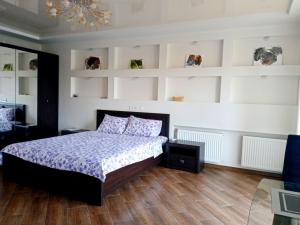 1 dormitorio con cama, paredes blancas y suelo de madera en 1-room Studio center, en Cherkasy