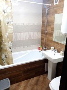 y baño con bañera y lavamanos. en 1-room Studio center, en Cherkasy