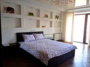 a bedroom with a bed and a wall of shelves at 1-room Studio center in Cherkasy