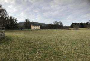 a large field with a house in the middle of it at Braemoray in Evanton