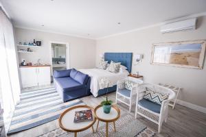 um quarto com uma cama, um sofá e uma mesa em Admiralty Beach House em Port Elizabeth
